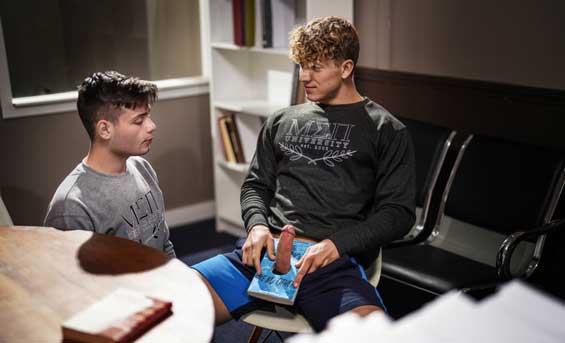 Ryan Bailey is trying to get some studying done at the college library, but his buddy Felix Fox is more interested in checking out the stern librarian, rubbing his cock through his pants, and making dirty jokes.