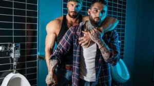 Tony D'Angelo knows that he only has to give one look to Travis Connor in this dimly lit truck stop restroom, and he'll have the burly trucker on his knees and inhaling his cock.