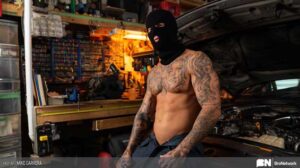 Mike Carrera is a hot grease monkey with a body of steel. Fast cars and fast living are what he’s all about. He’s out in the shop working on his sports car.